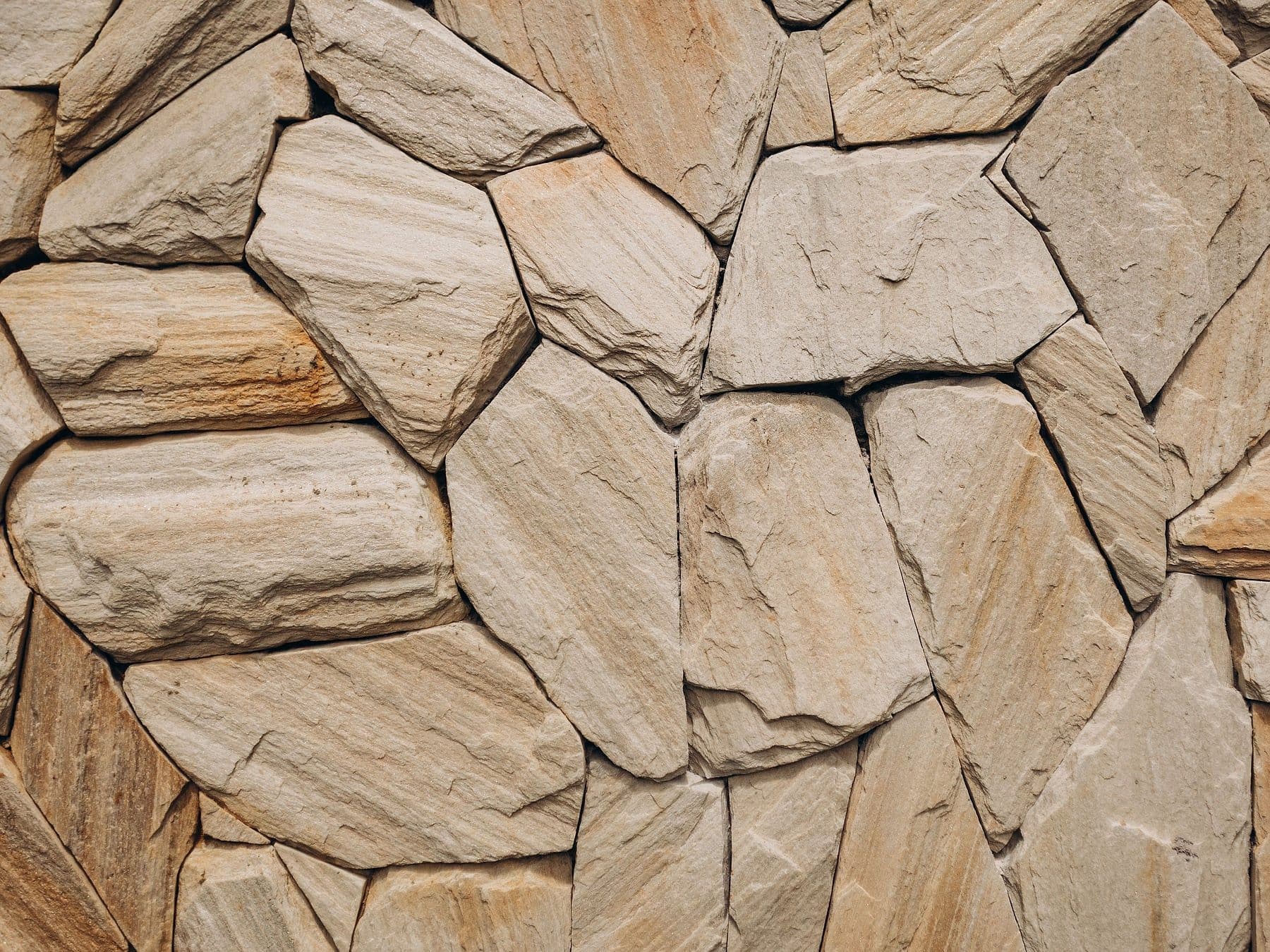 Natural flagstone masonry wall with tan and grey stones